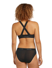 Woman wearing black Icebreaker Sprite Racerback Bra that criss-crosses in the back